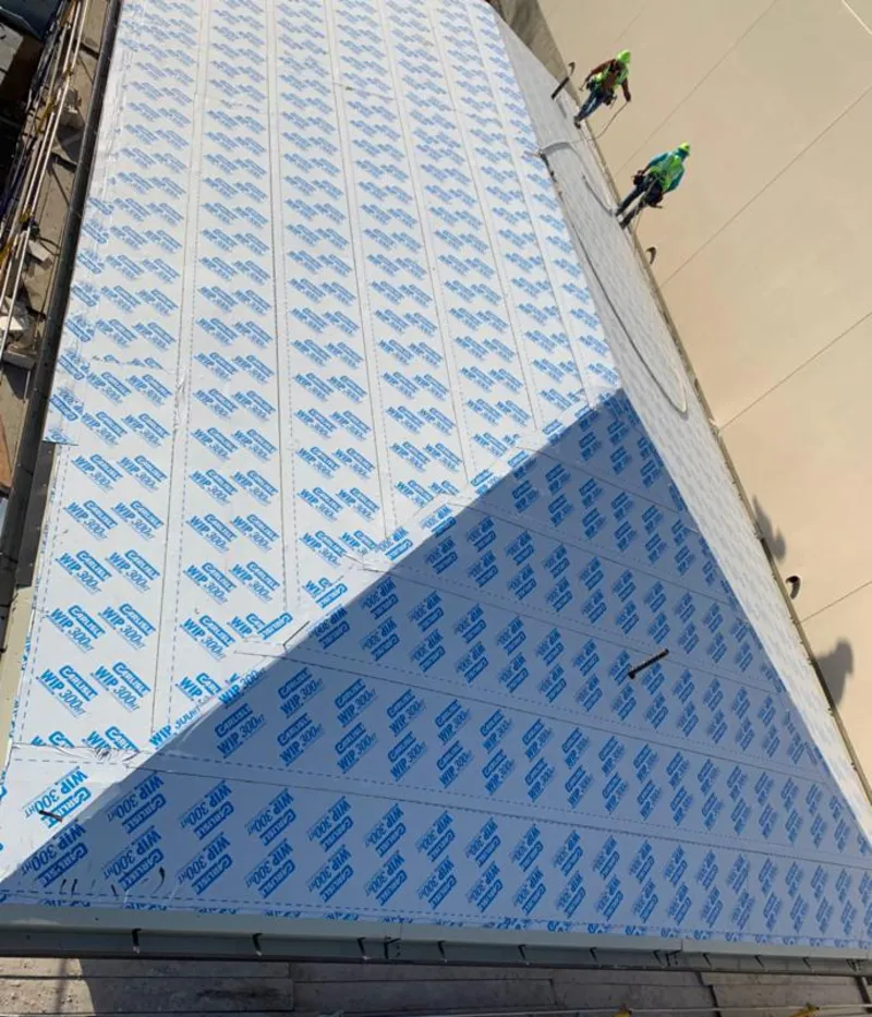 Professional roofers installing underlayment on a metal roof in West Dundee